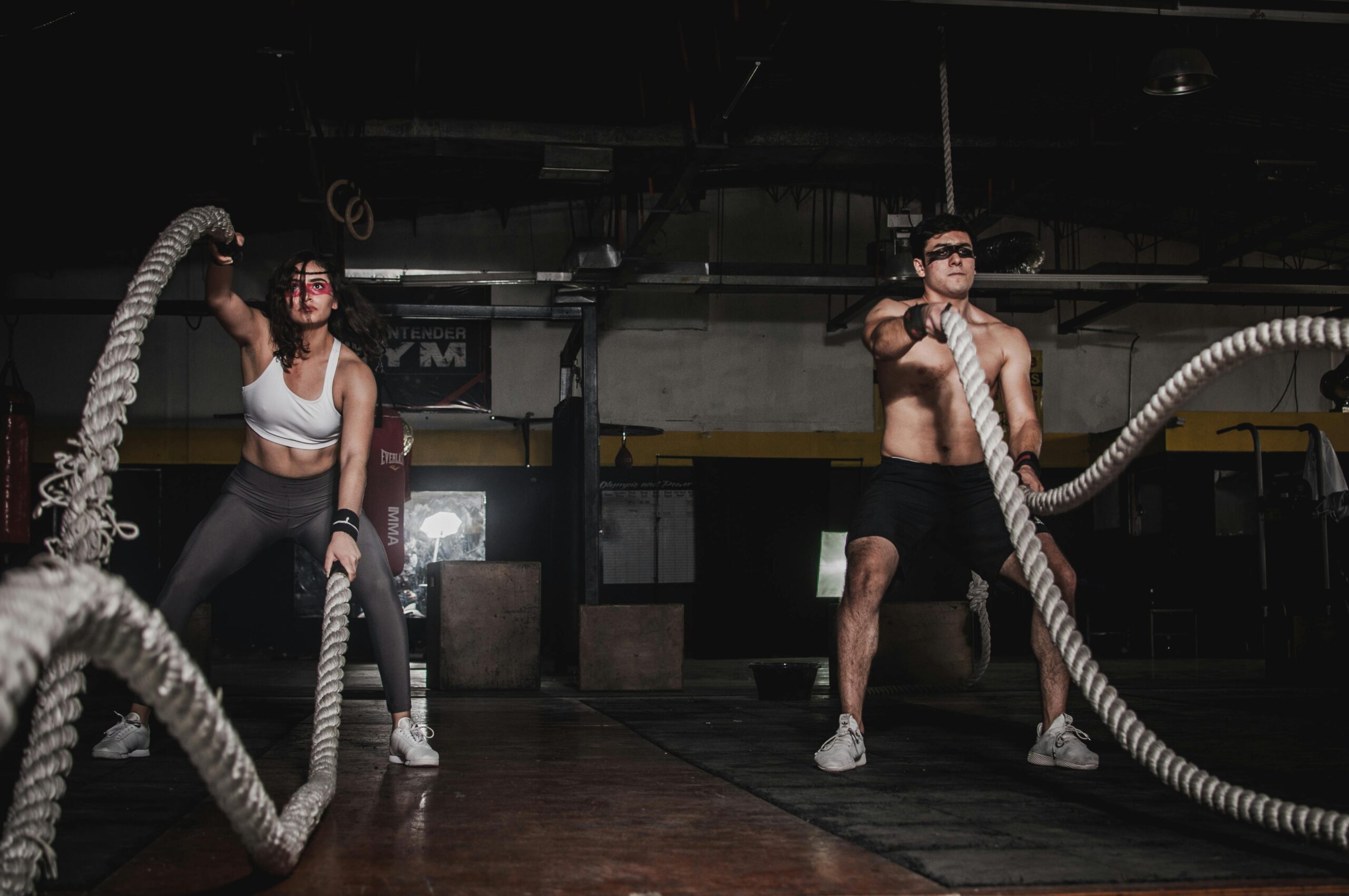 a man and woman working out with ropes